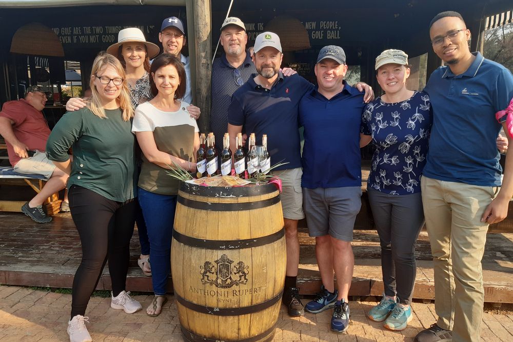 Wine blending team with their finished bottles on a wine barrel